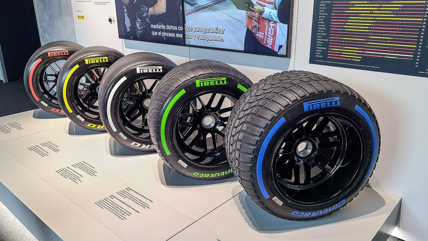 A row of Pirelli racing tires with colored sidewall markings on display