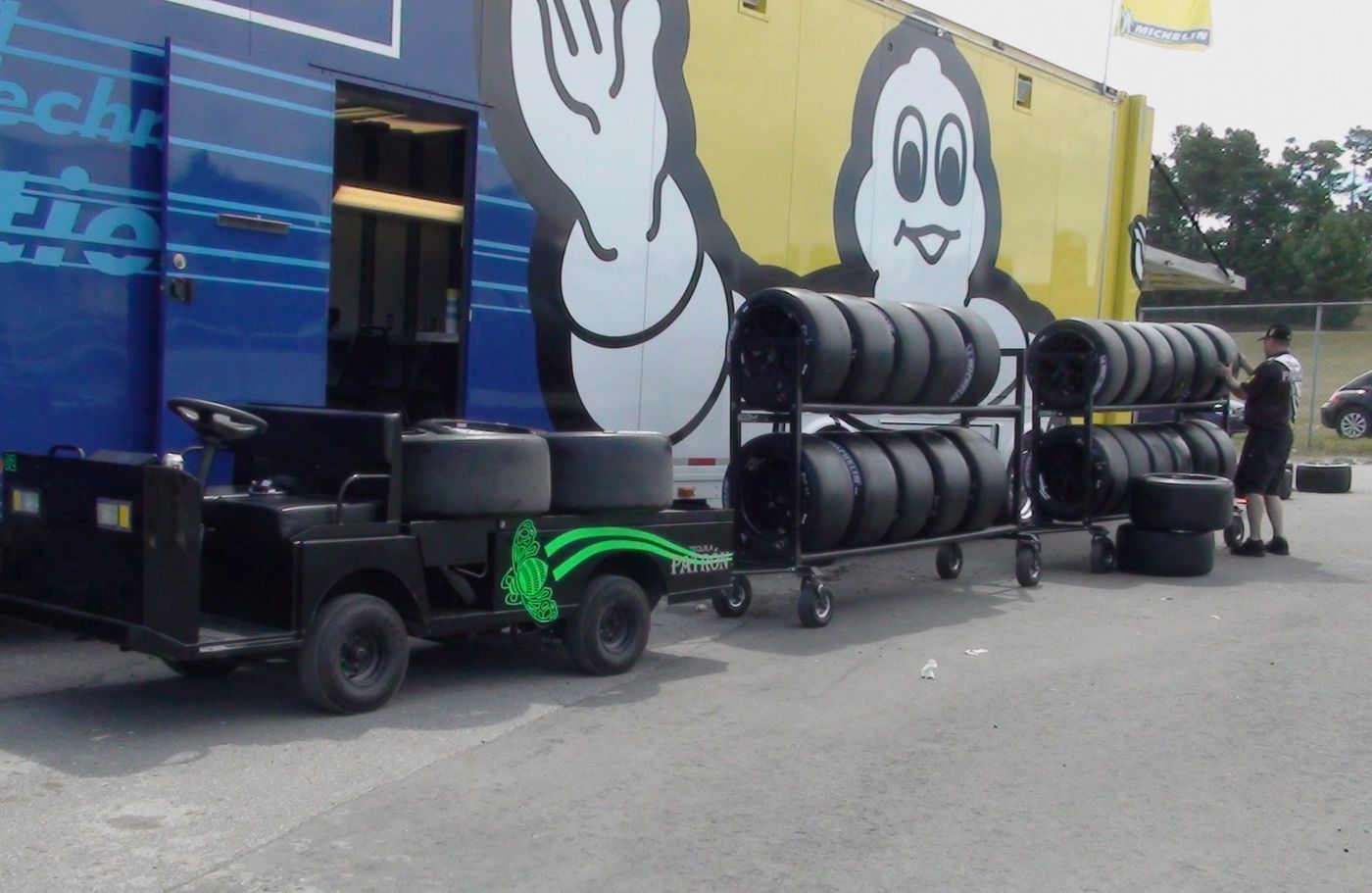 Michelin racing tires on racks beside a Michelin race transporter