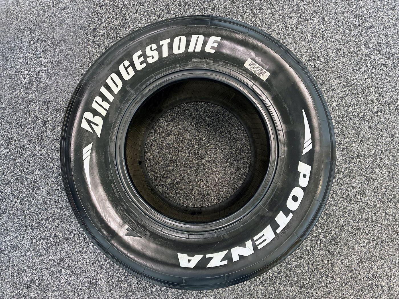 Bridgestone Potenza racing tire with white sidewall lettering, seen from above