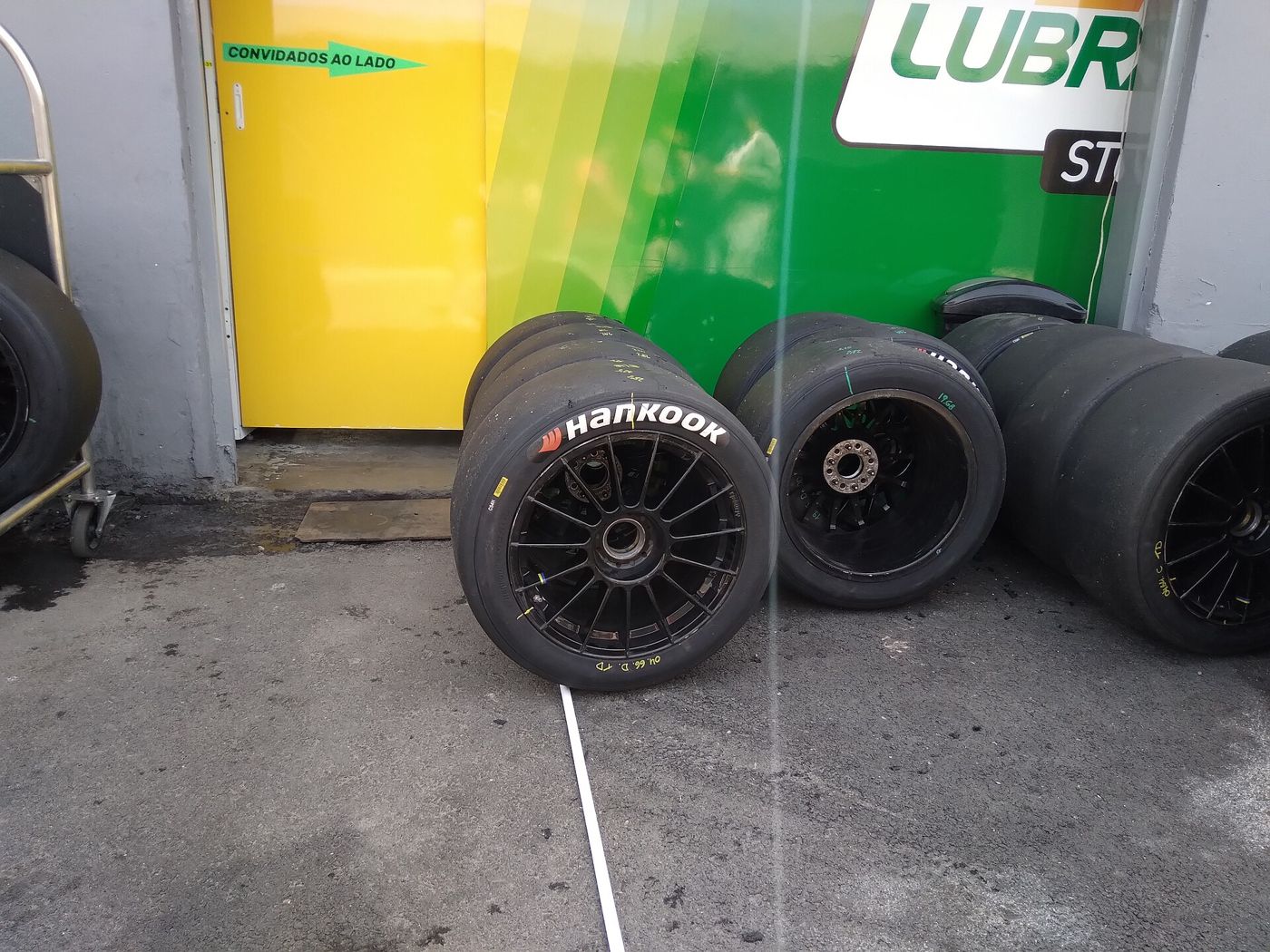 Hankook racing slick tires stacked beside a race transporter