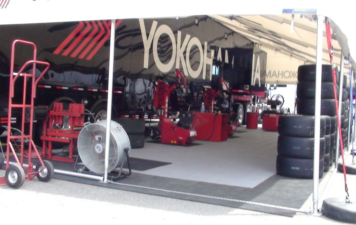 Yokohama race-service area with stacked tires and a Yokohama transporter