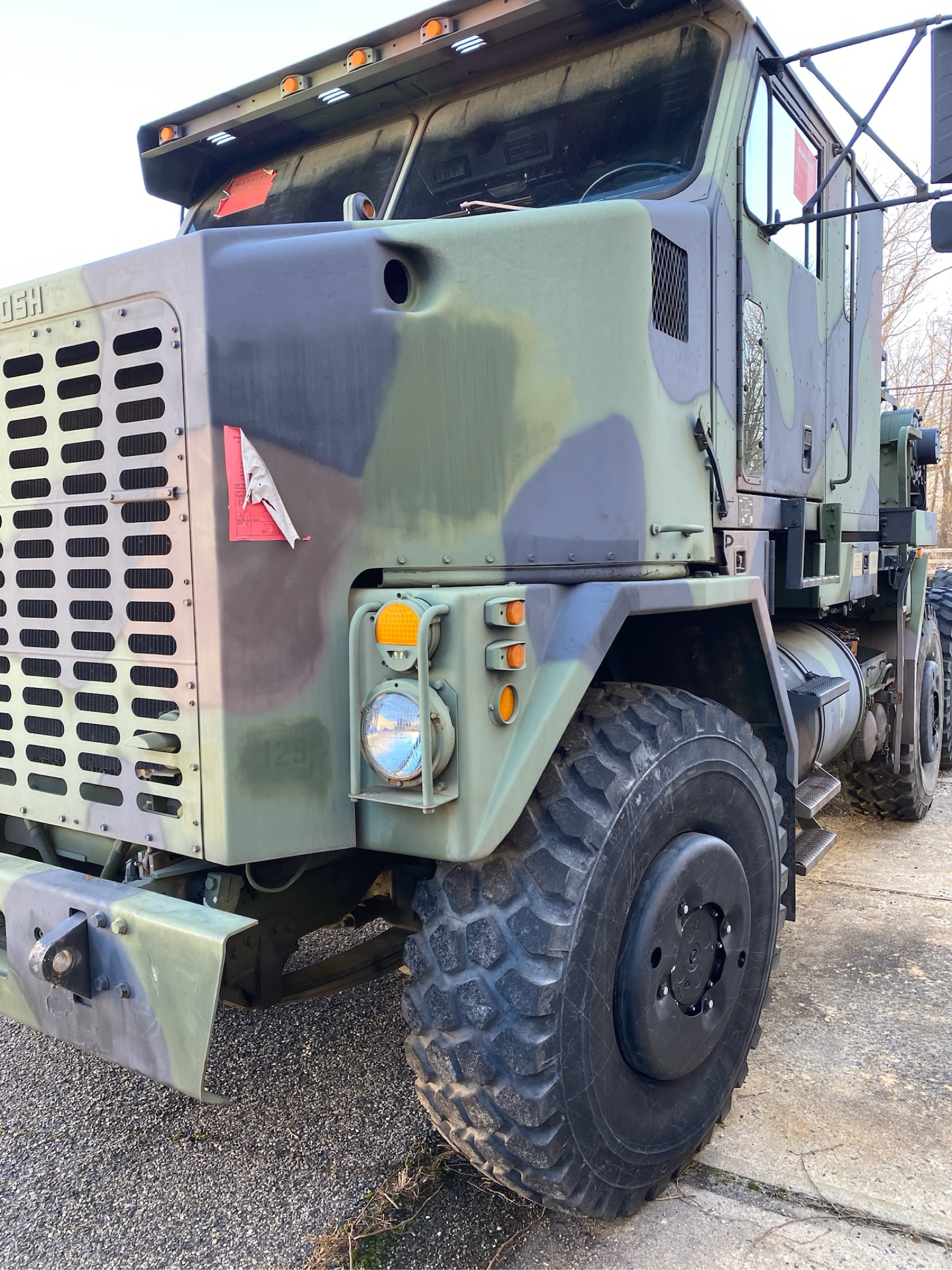 Camouflage Oshkosh heavy equipment transporter, front view