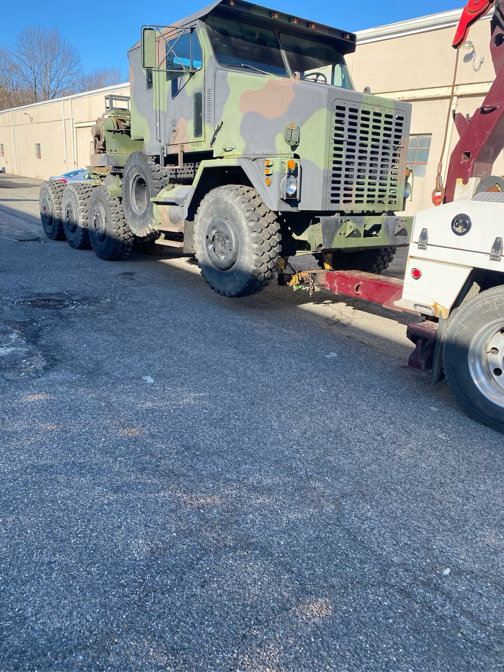 Heavy equipment transporter being towed by a wrecker truck